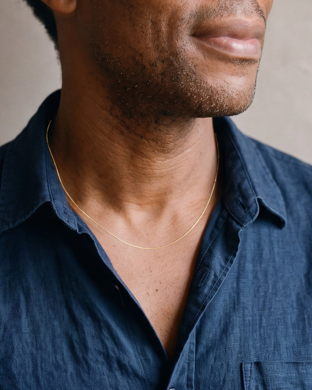 Close-up of the Atlas 0.9 mm snake chain in gold-tone steel worn, true size