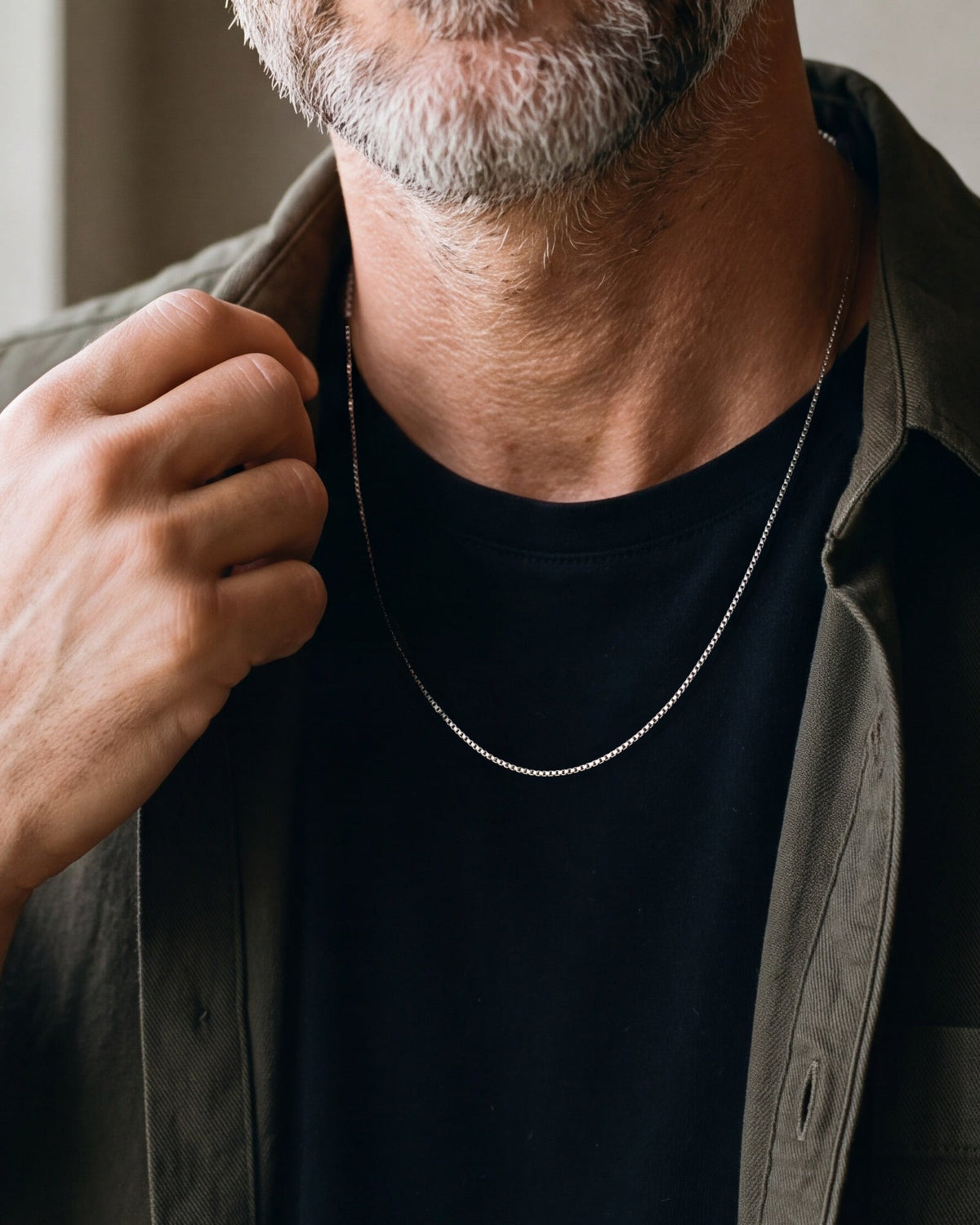 Close-up of the silver-tone Atlas 1.5 mm box chain worn by a man, true size