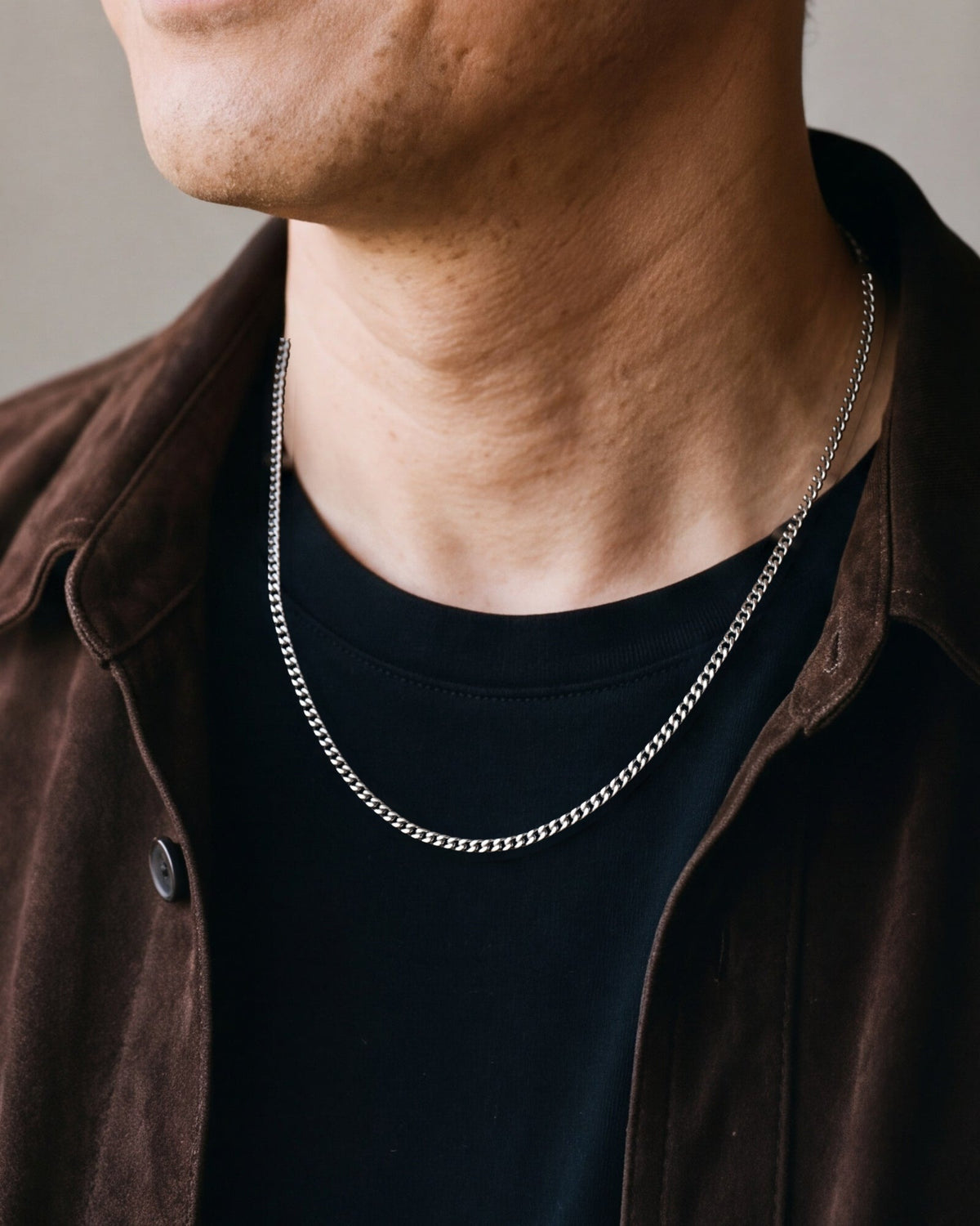 Close-up of the slim 3 mm silver Atlas Cuban chain at the collar worn, true size