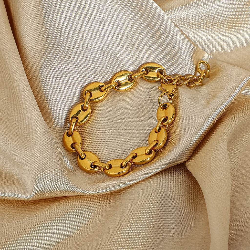 Gold-Tone Coffee Bean Link Bracelet on a light gold fabric background view 4