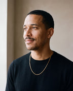 Man in a black merino sweater seen in profile wearing the gold-tone Atlas 1.5 mm box chain