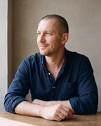 Man in a dark navy cotton oxford shirt by a window wearing the silver Atlas 1.5mm Box Chain