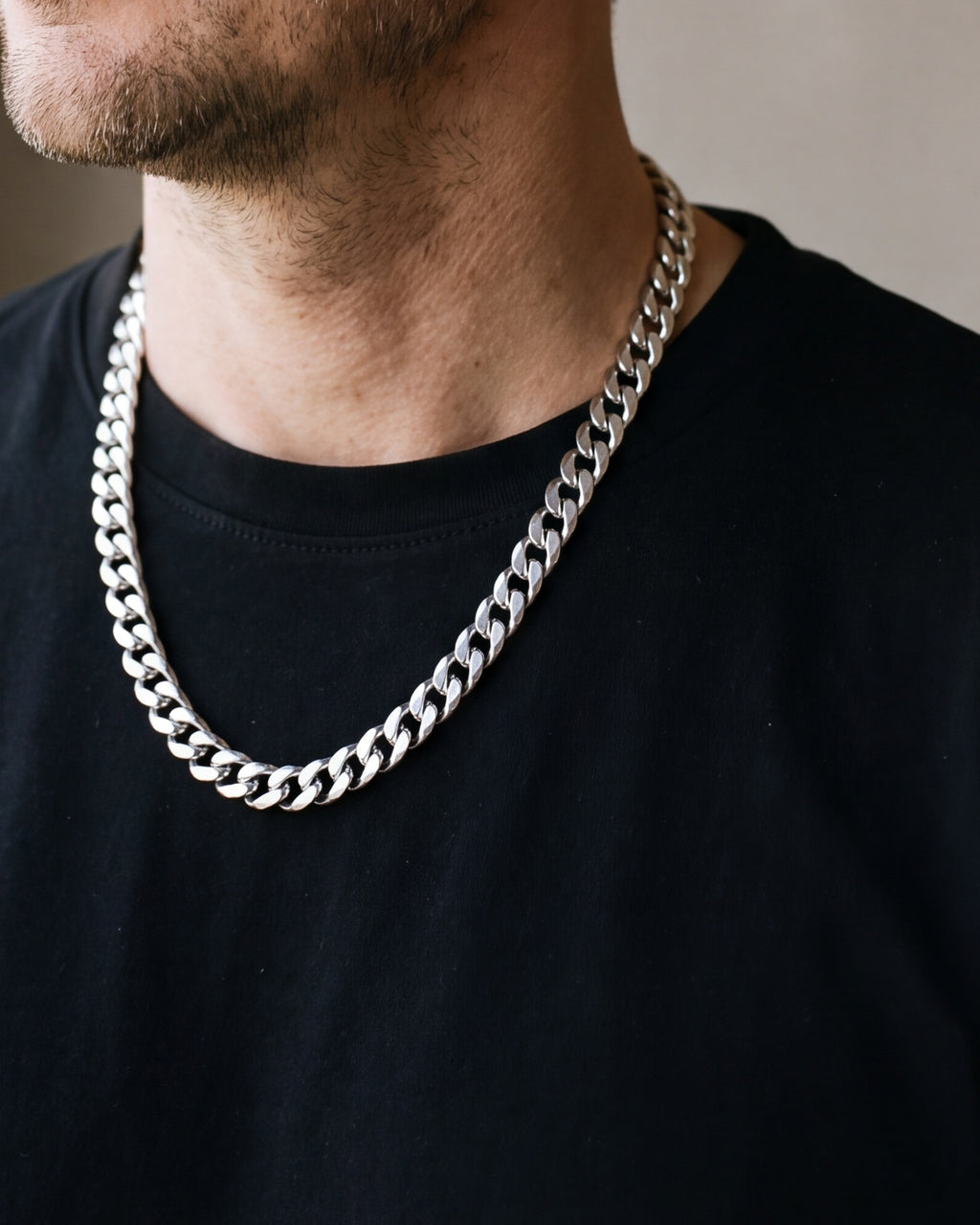 Close-up of the 10 mm silver Atlas Cuban link chain worn with a black T-shirt, shown at true size