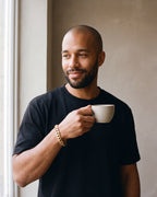 Man in a black t-shirt wearing the Atlas 10 mm Cuban link bracelet in gold-tone steel
