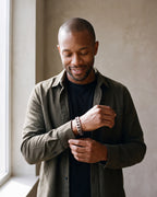 Man in a dark olive overshirt open over a black t-shirt wearing the silver Atlas 11mm Cuban Link Bracelet