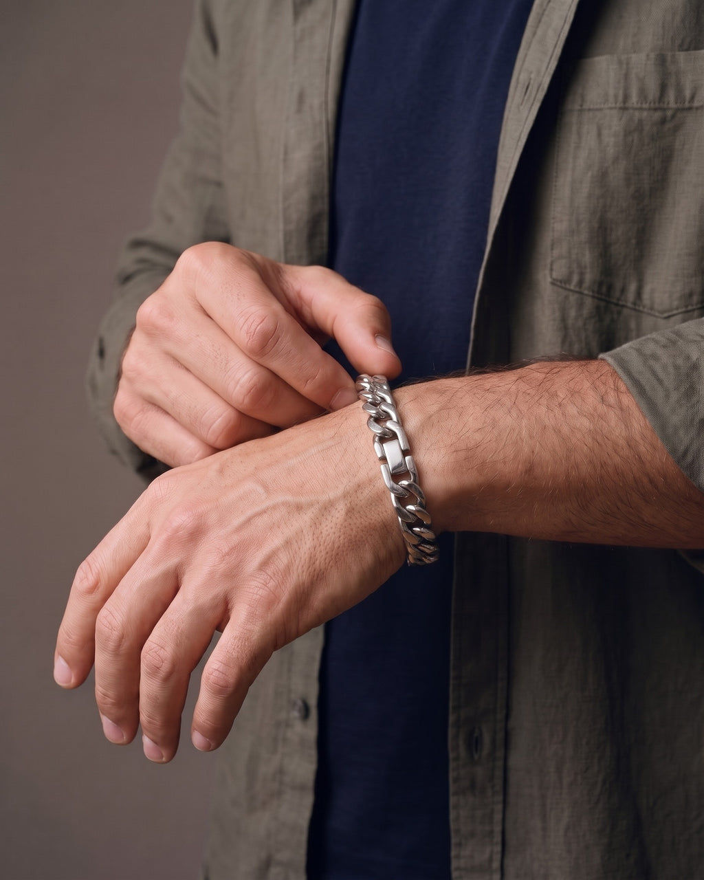 Hand adjusting the Atlas 11mm Silver Cuban Link Bracelet on the wrist