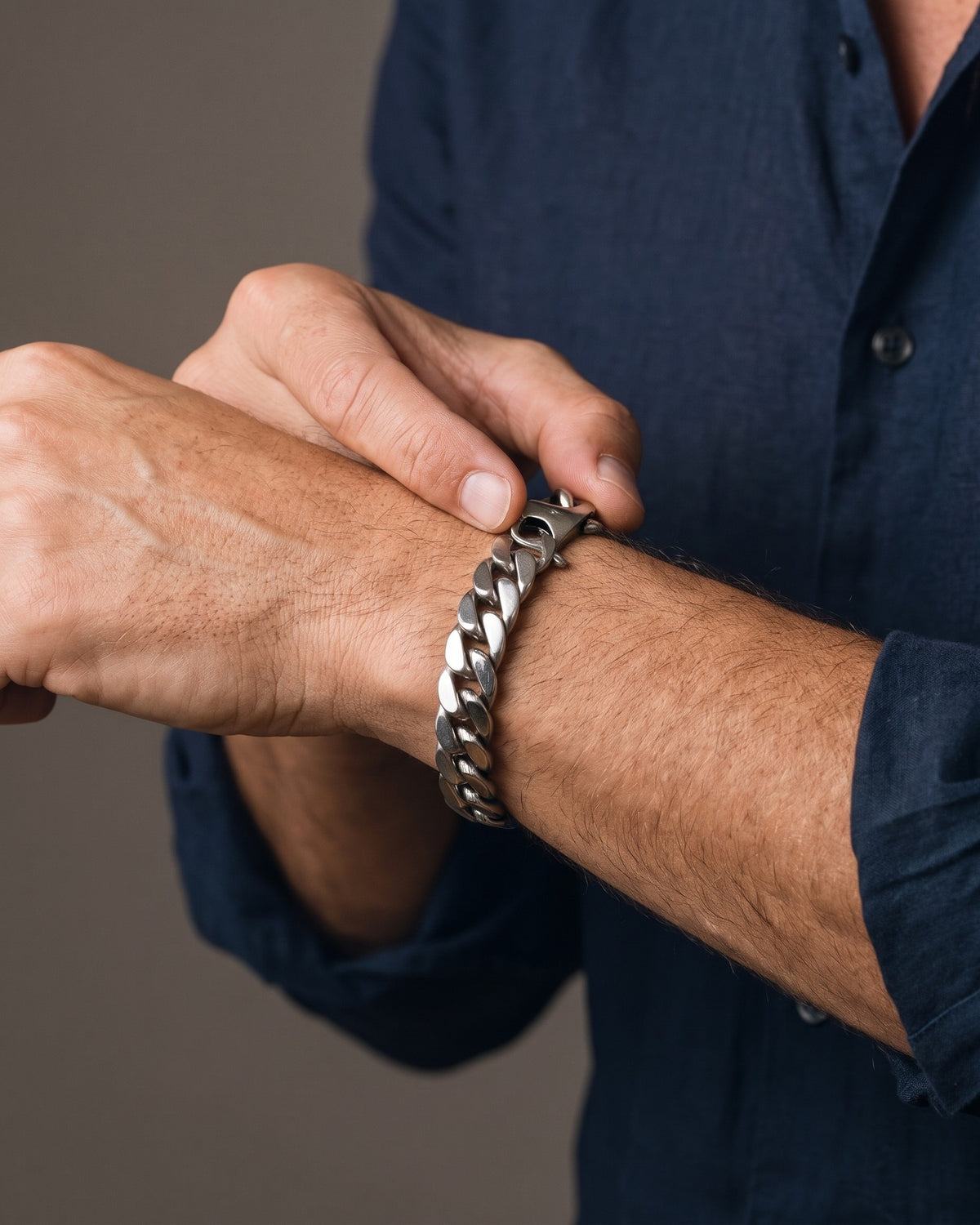 Hand adjusting the Atlas 15mm Titanium Steel Cuban Bracelet on the wrist