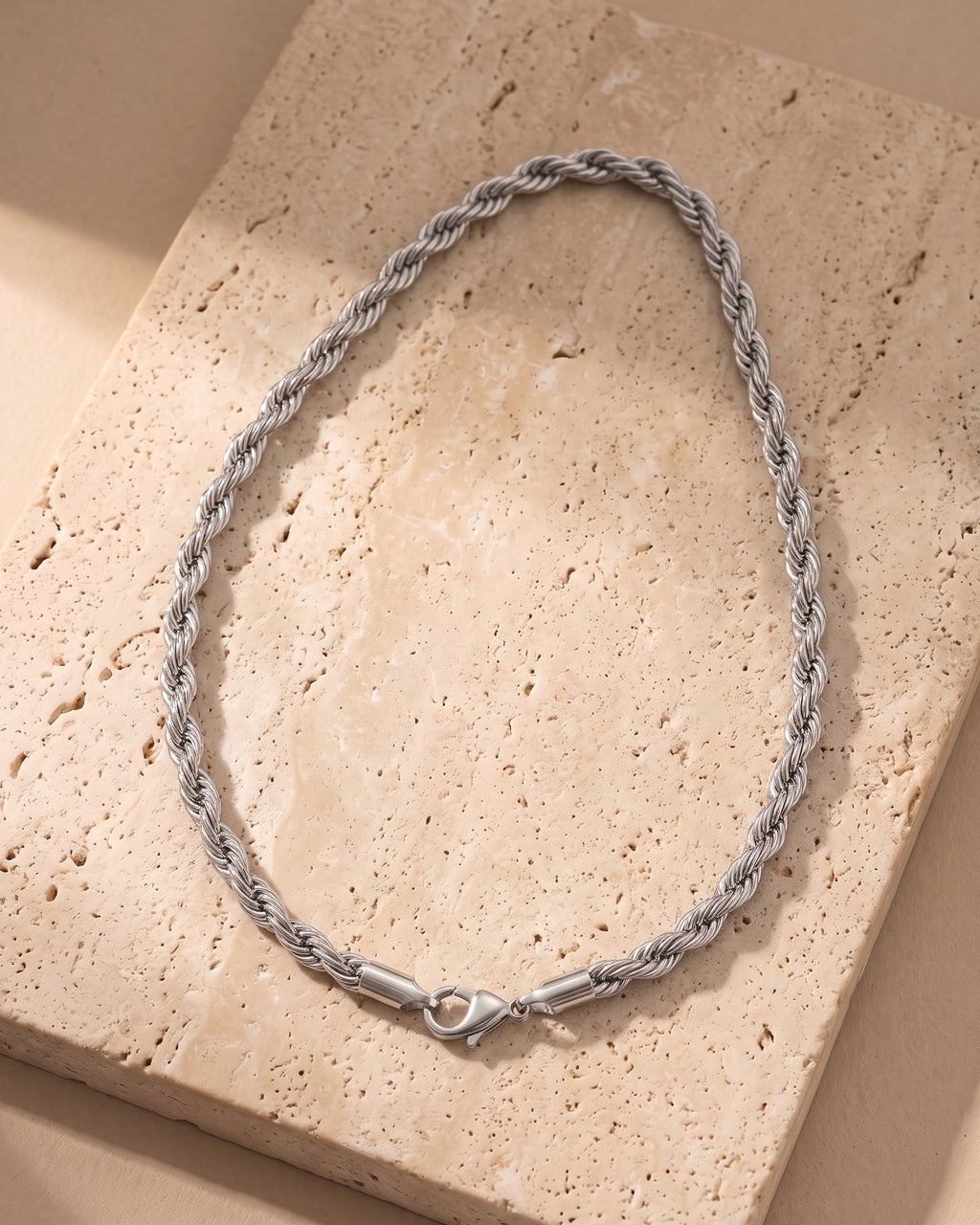 Silver-tone Atlas 2.5 mm rope chain laid whole on warm stone