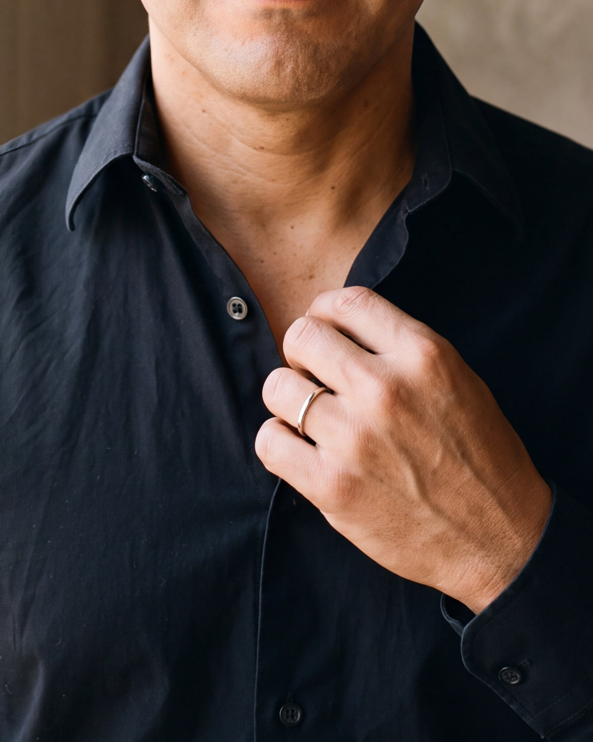 Close-up of the silver-tone Atlas 2 mm polished band worn by a man, shown at true size