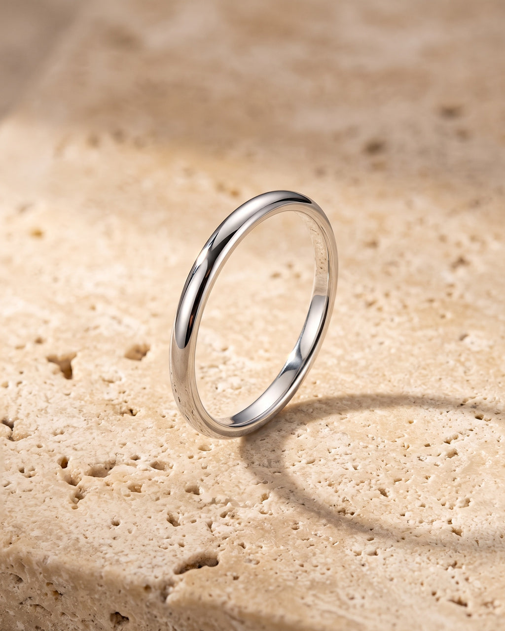 The whole silver-tone Atlas 2 mm polished band laid on warm stone