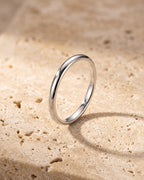 The whole silver-tone Atlas 2 mm polished band laid on warm stone