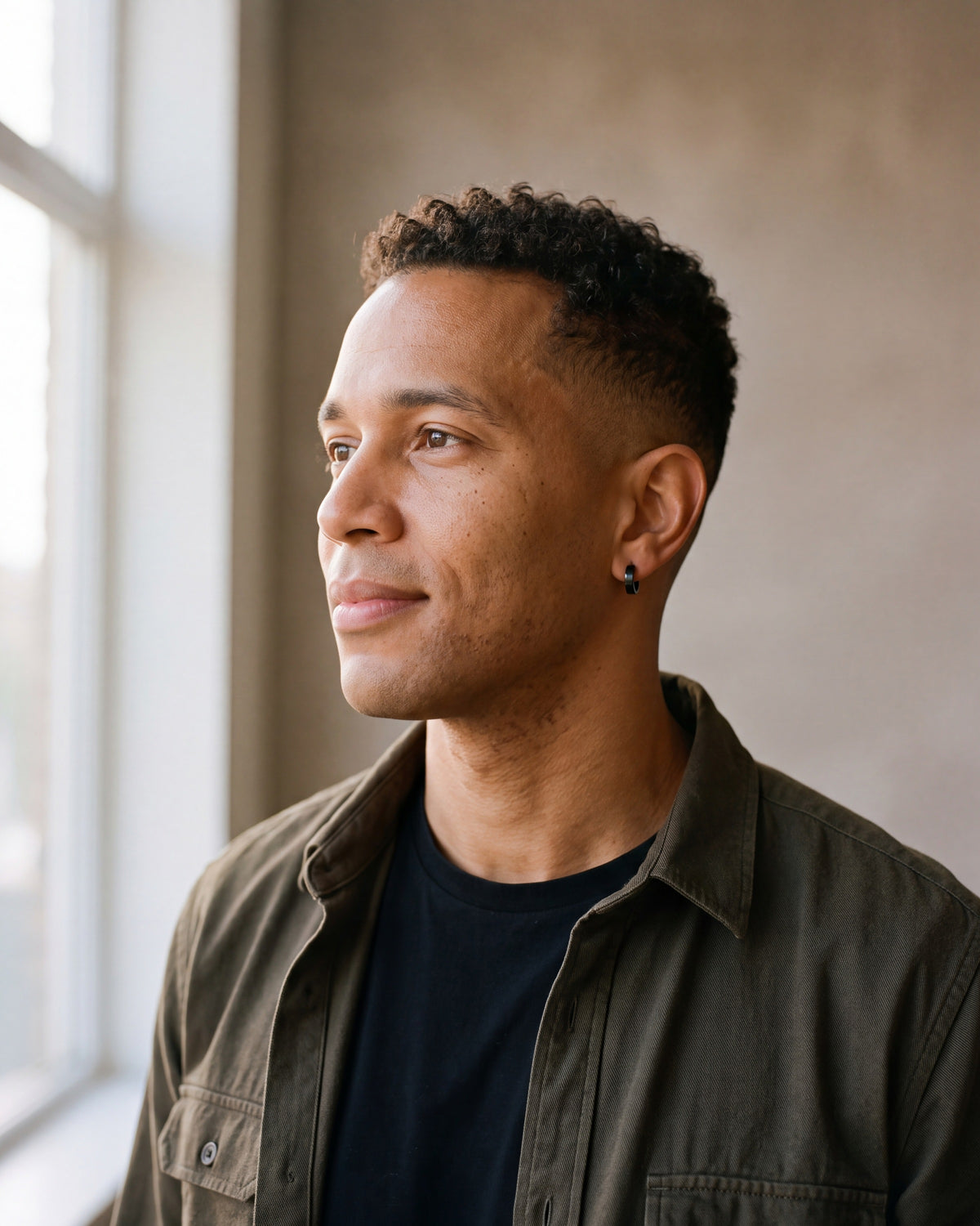 Second man in a dark olive overshirt open over a plain black t-shirt wearing the black Atlas 4mm hoop earrings