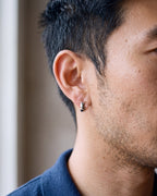 Close-up of the silver-tone Atlas 4mm hoop earrings worn, true size