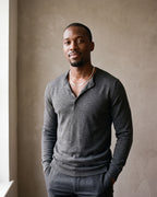Man in a charcoal knit henley by a window wearing the Atlas 5 mm flat snake chain in silver-tone steel