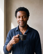 Man in a dark navy linen shirt by a window wearing the Atlas 5 mm rope chain bracelet in silver-tone steel