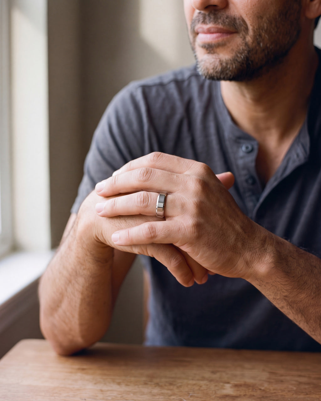 Close-up of the silver-tone Atlas 6 mm beveled band worn by a man, shown at true size