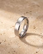 The whole silver-tone Atlas 6 mm beveled band laid on warm stone