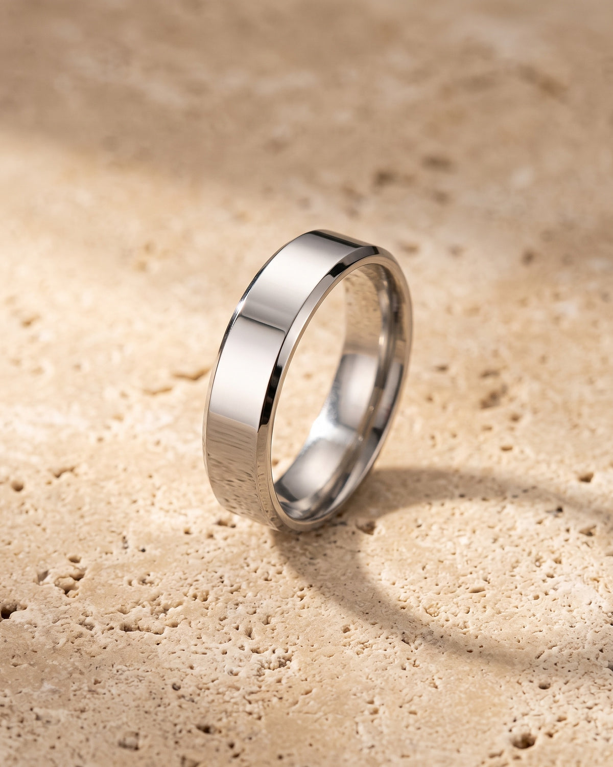 The whole silver-tone Atlas 6 mm beveled band laid on warm stone