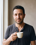 Man in a charcoal henley holding a coffee cup wearing the gold-tone Atlas 6 mm geometric cut-out ring