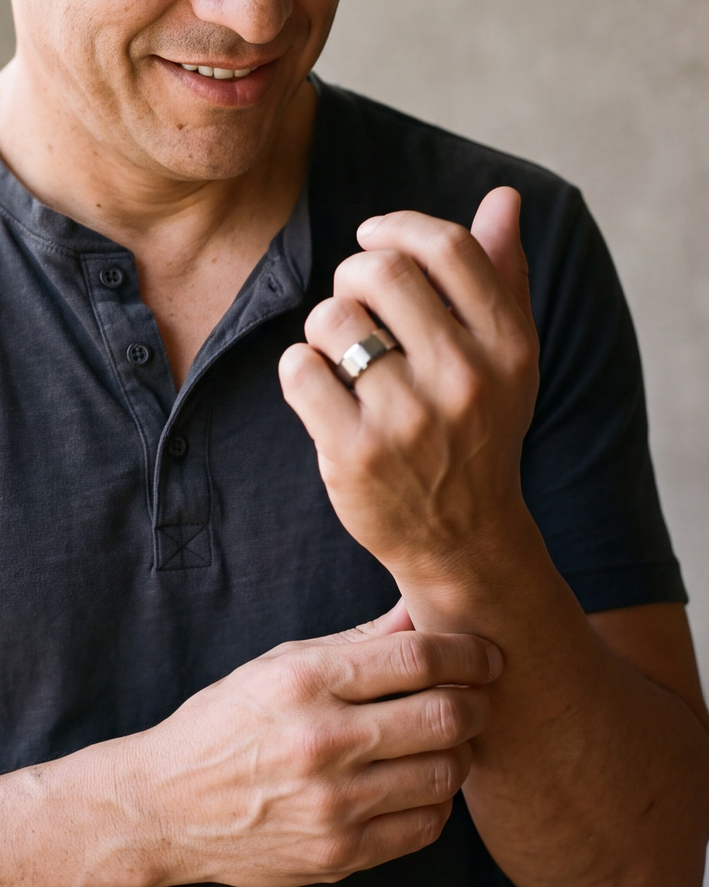 Close-up of the silver-tone Atlas 8 mm matte tungsten carbide band worn by a man, shown at true size