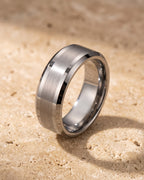 The whole silver-tone Atlas 8 mm matte tungsten carbide band laid on warm stone