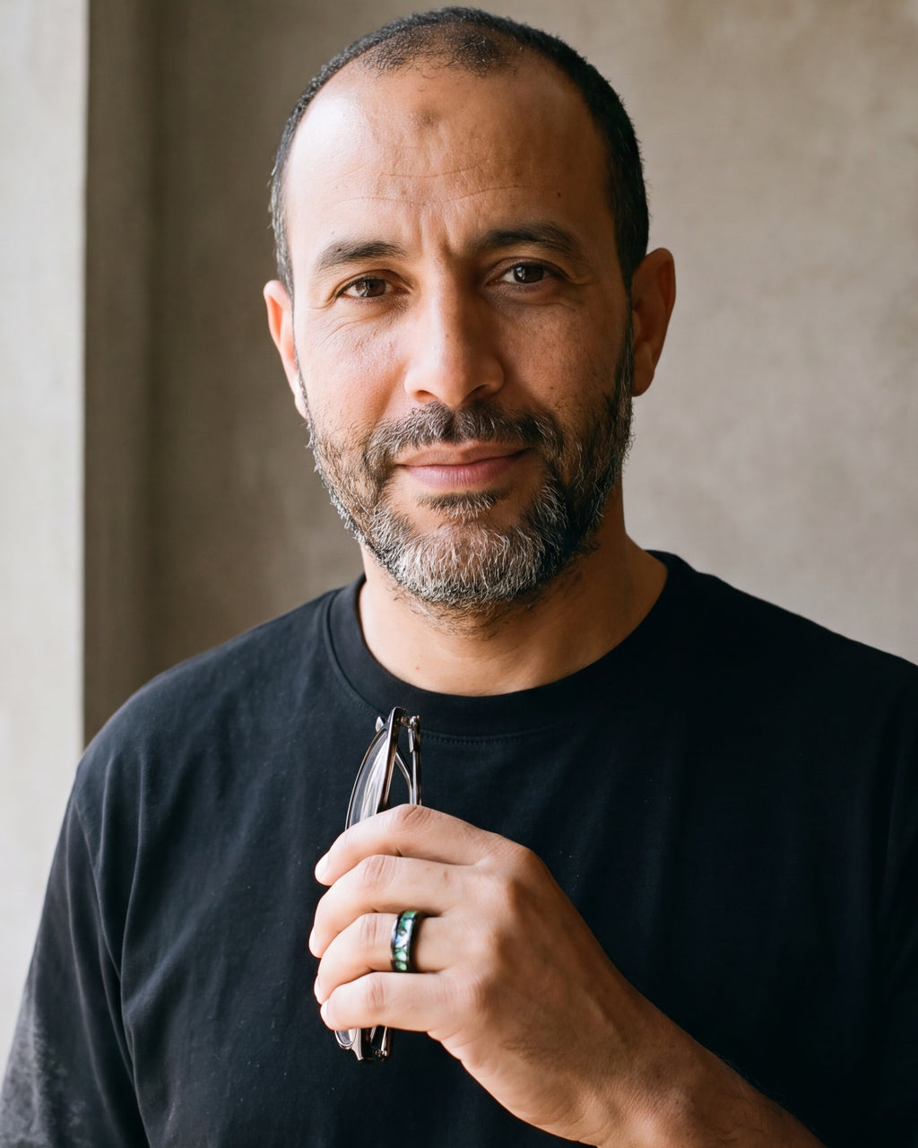 Man in a black t-shirt looking at the camera, wearing the 8 mm Atlas abalone inlay black band
