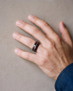 Close-up of the Atlas wood and opal black tungsten band on a man's hand