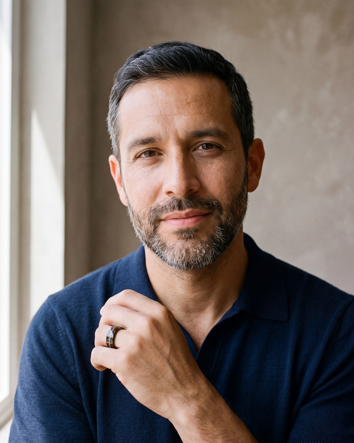 Man in a navy shirt wearing the Atlas wood and opal tungsten band