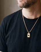 Close-up of the gold-tone Atlas ace of spades pendant necklace worn, true size