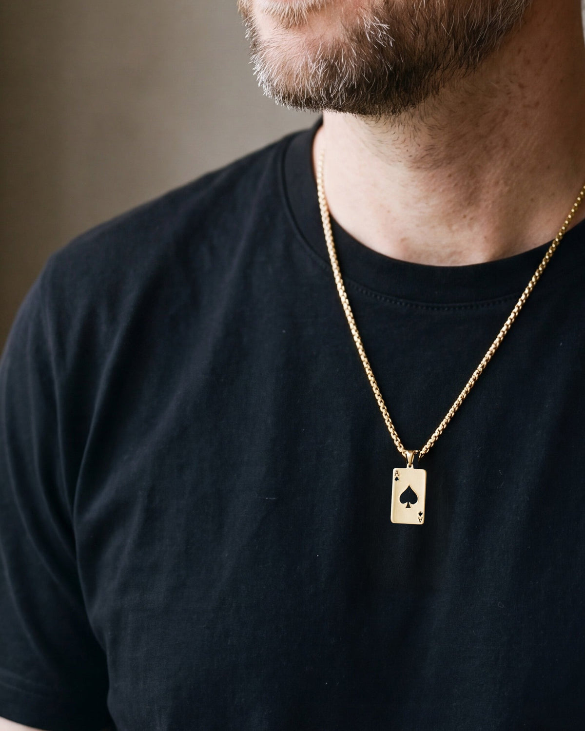 Close-up of the gold-tone Atlas ace of spades pendant necklace worn, true size