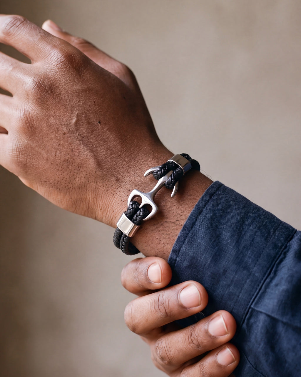 Close-up of the silver Atlas anchor bracelet on a man's wrist at true size, two braided leather strands