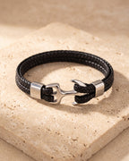Silver Atlas braided leather anchor bracelet closed on warm travertine stone