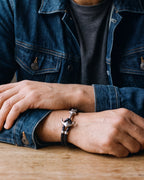 Close-up of the Atlas anchor hook bracelet in braided leather in black steel, worn at true size