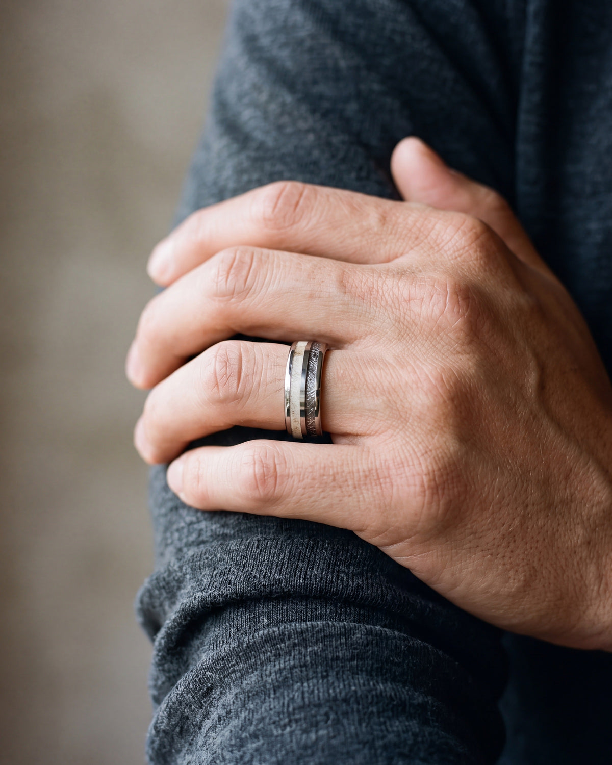 Close-up of the Atlas antler and meteorite inlay ring on a man's hand
