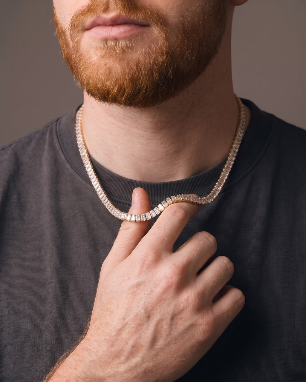 Hand lifting the Atlas Baguette Tennis Chain at the collarbone