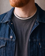 Close-up of the gold-tone Atlas Baguette Tennis Chain worn by a man, shown at true size