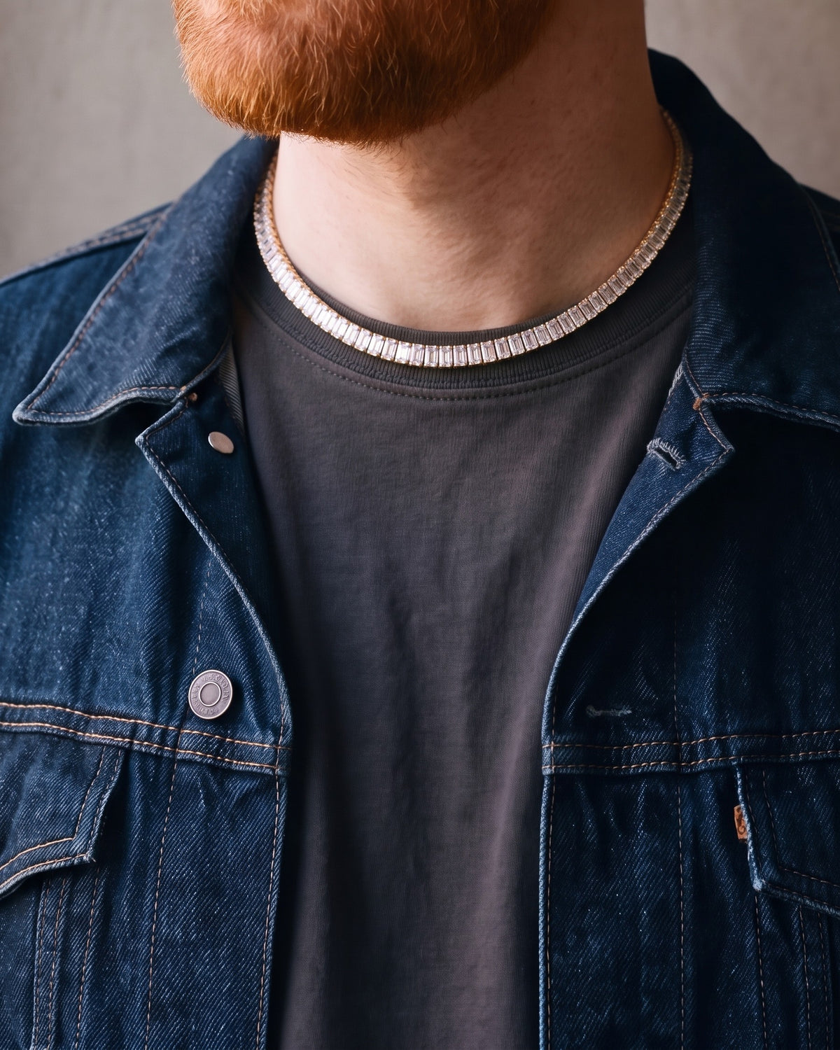 Close-up of the gold-tone Atlas Baguette Tennis Chain worn by a man, shown at true size