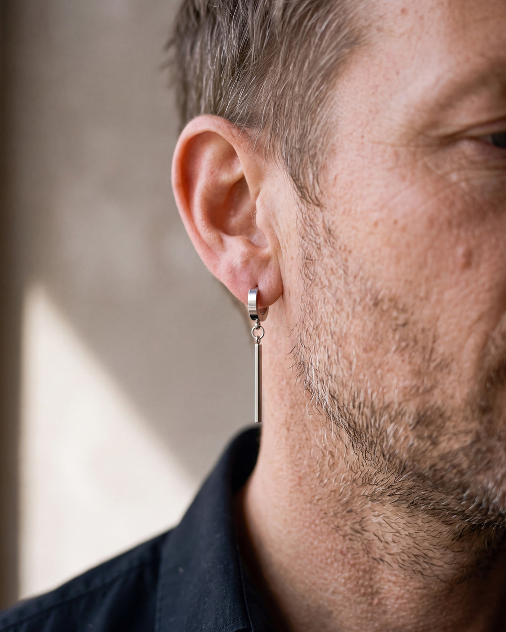 Close-up of the silver-tone Atlas bar drop hoop earrings worn at true size