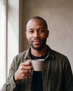 Man in a dark olive overshirt open over a black t-shirt wearing the blue Atlas Beveled Edge Band Ring