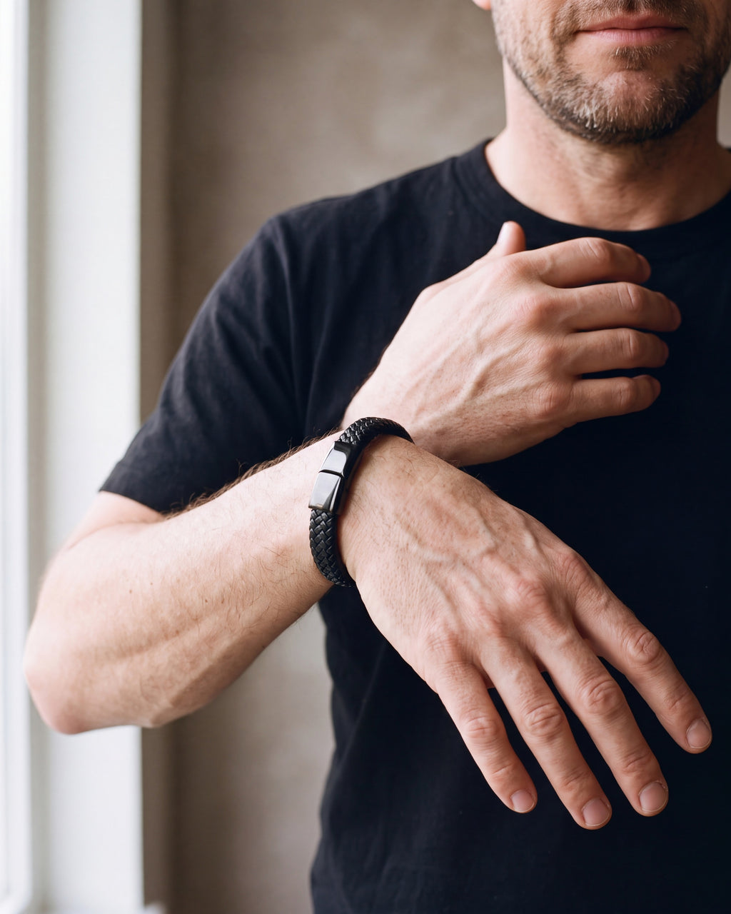 Close-up of the black Atlas black braided leather magnetic bracelet worn by a man, shown at true size