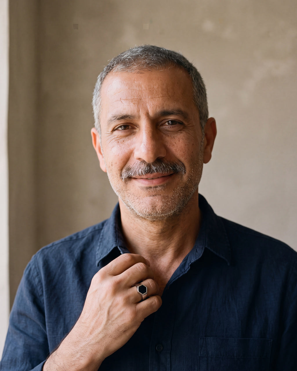 Man in a navy shirt wearing the Atlas black hexagon signet ring