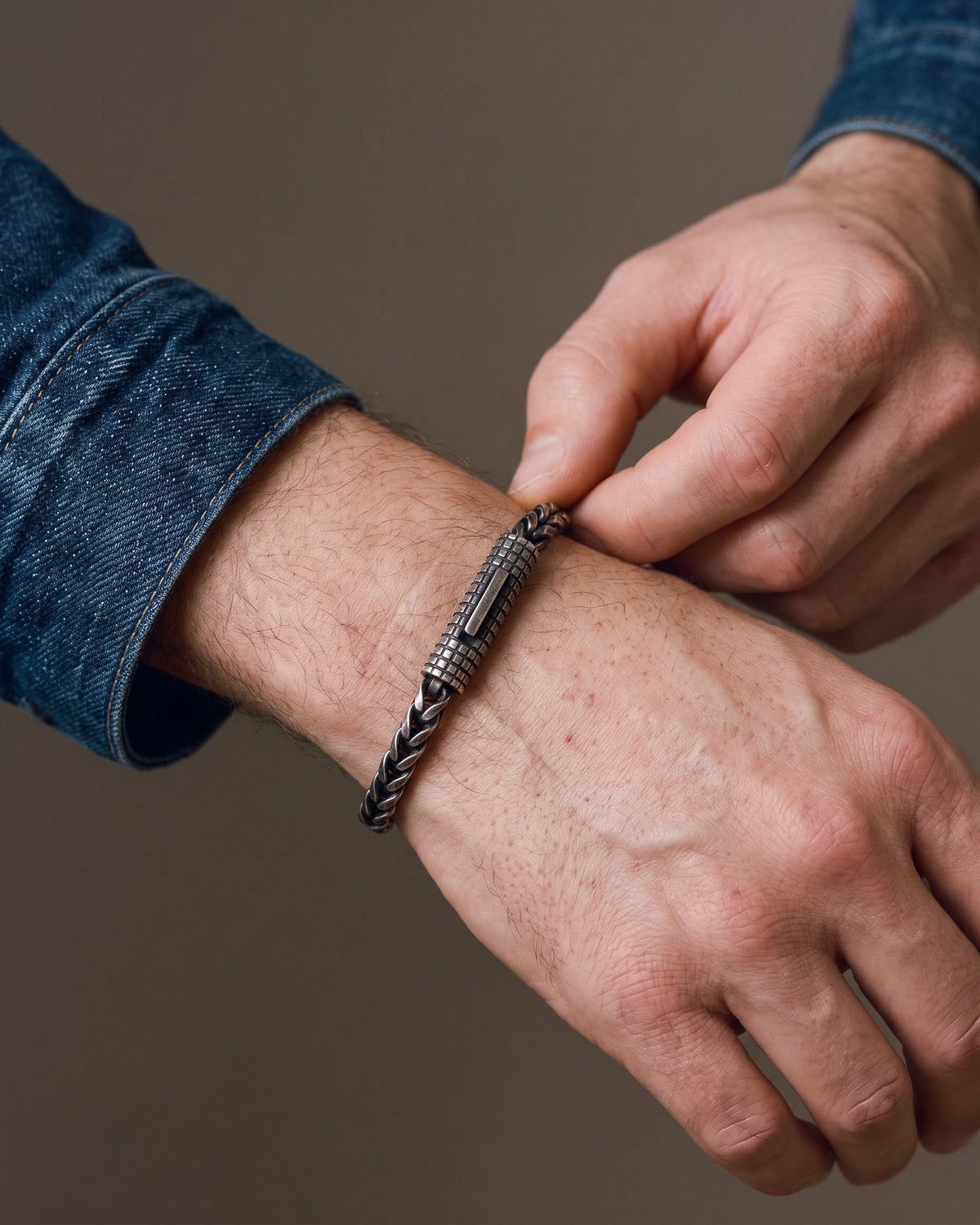Hand adjusting the Atlas Black Wheat Chain Bracelet on the wrist