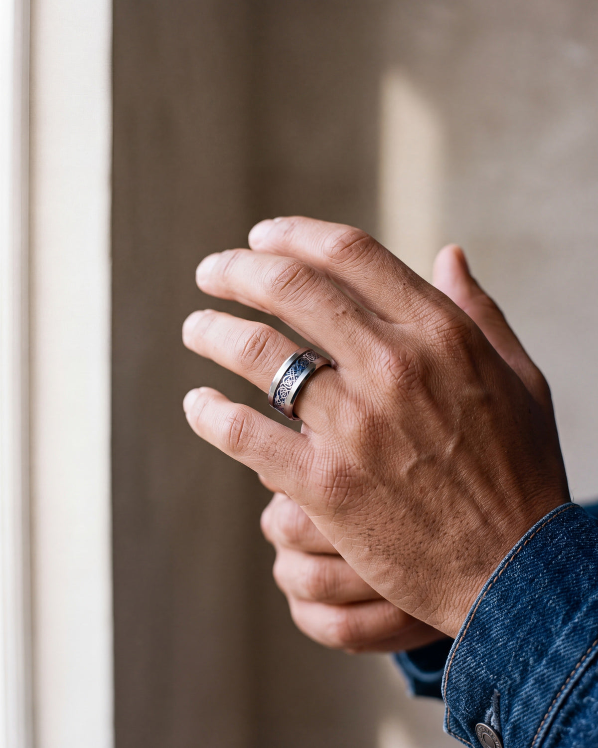 Close-up of the Atlas blue Celtic knot ring on a man's hand