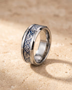 The Atlas blue Celtic knot tungsten ring standing on warm stone