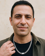 Man in an olive overshirt with his hand at the collar, wearing the 6 mm silver Atlas box clasp Miami Cuban chain