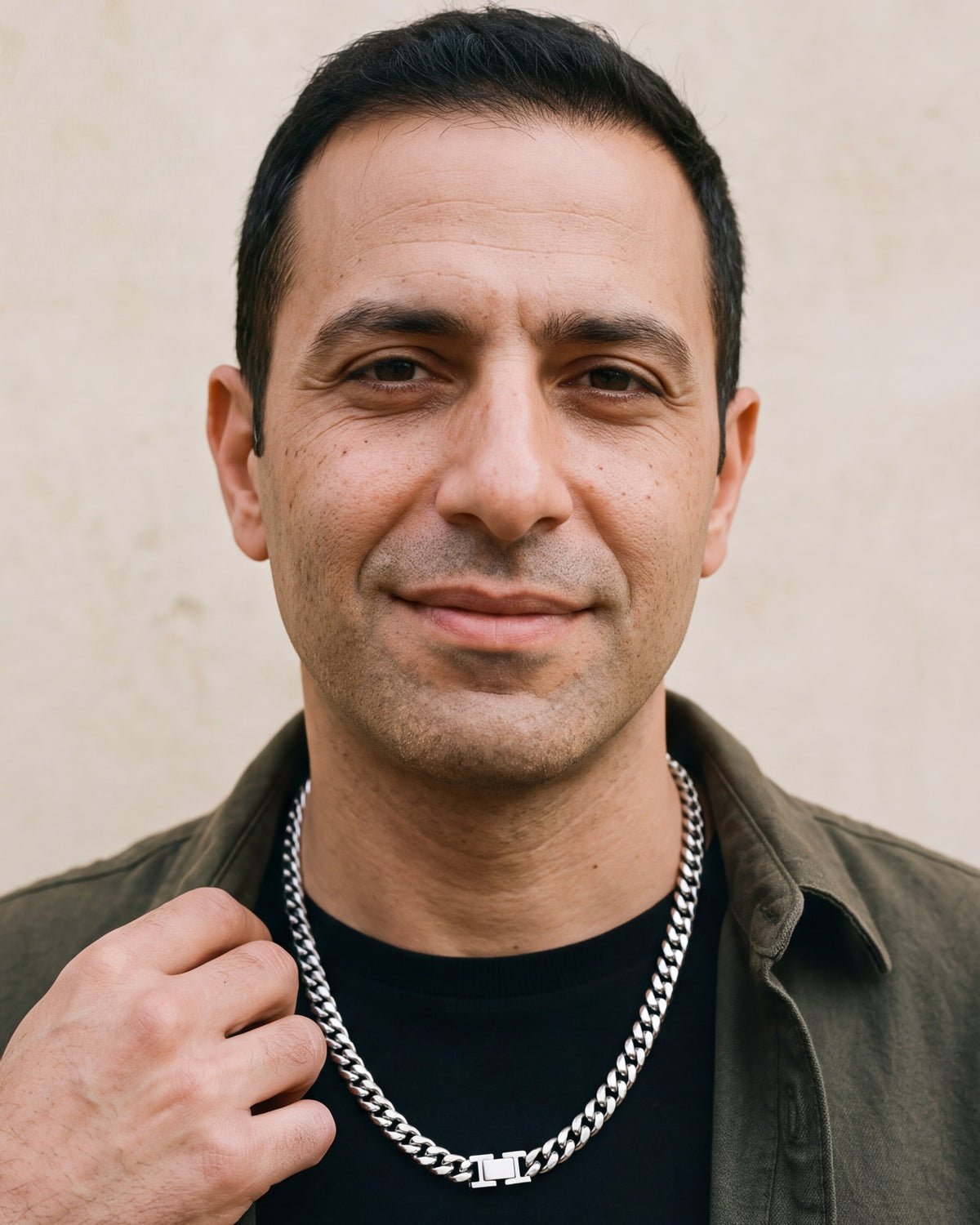 Man in an olive overshirt with his hand at the collar, wearing the 6 mm silver Atlas box clasp Miami Cuban chain