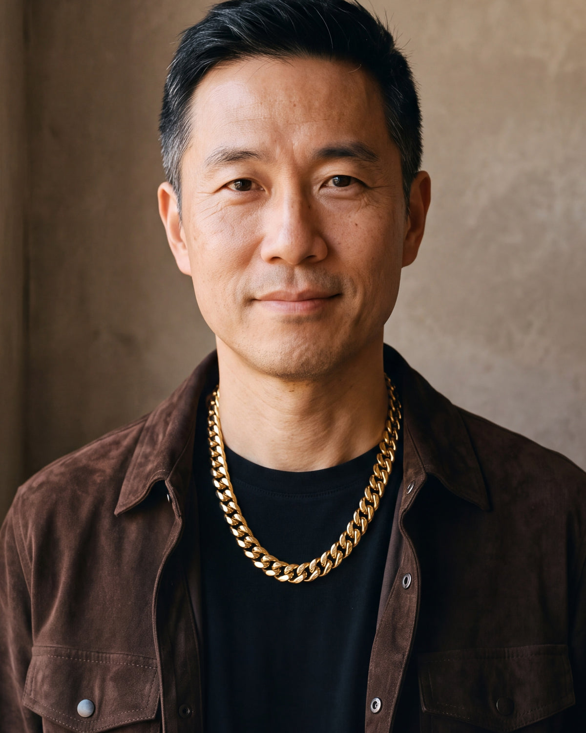 Man in a brown suede overshirt looking at the camera, wearing the 10 mm gold-tone Atlas box clasp Miami Cuban chain