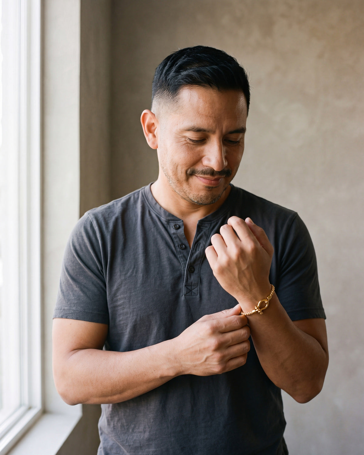 Second man in a charcoal cotton henley t-shirt wearing the gold-tone Atlas box link shackle bracelet