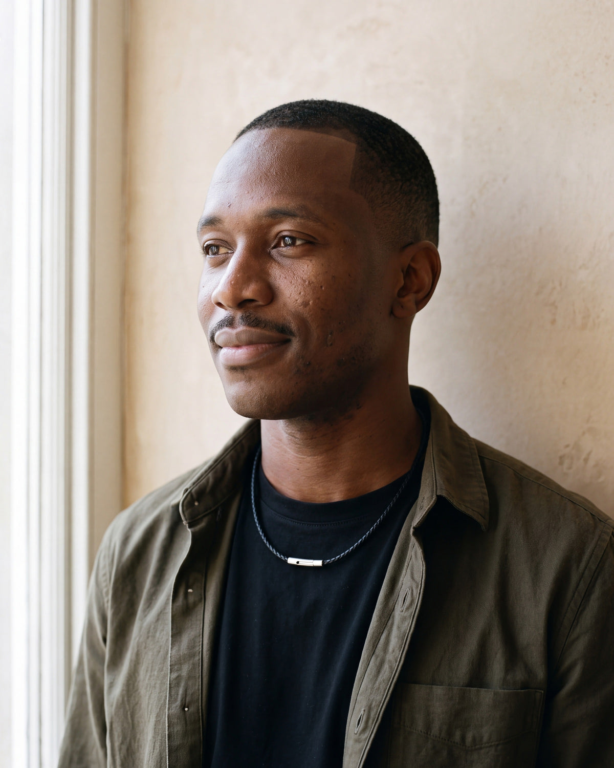 Man in an olive overshirt wearing the Atlas 3 mm black braided cord necklace
