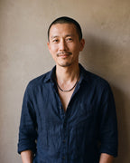 Man in a navy linen shirt wearing the Atlas black braided cord necklace
